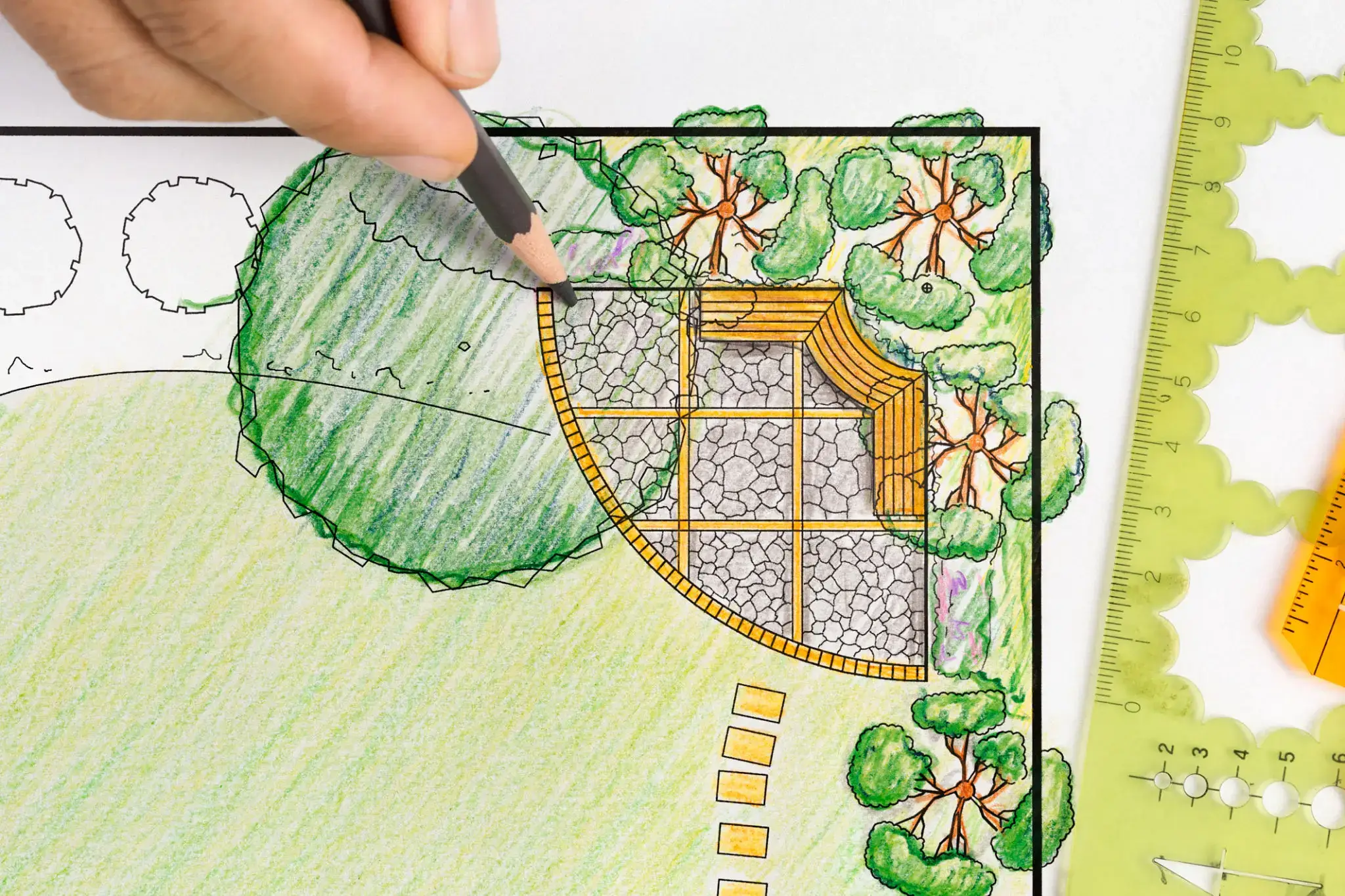 Hand drawing a detailed garden landscape plan with colored pencils.